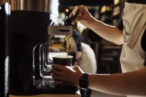 A Bitty & Beau's barista pouring a cup of coffee